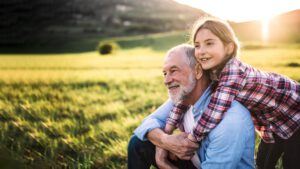 Grandfather and granddaughter in a field